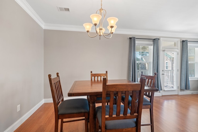222 Sheffield Dr Unit E-5, Sparta, GA 31087 - dining space with light wood-style floors, an inviting chandelier, ornamental molding, and visible vents