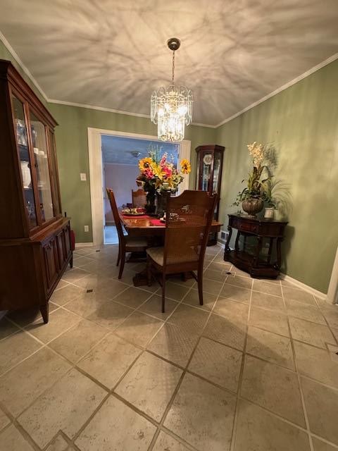 dining room with a chandelier, light tile patterned floors, and crown molding