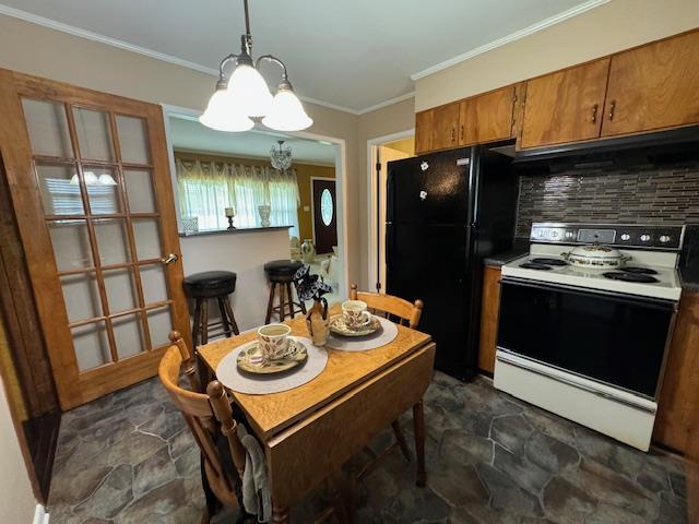 kitchen featuring tasteful backsplash, black fridge, pendant lighting, an inviting chandelier, and white electric stove