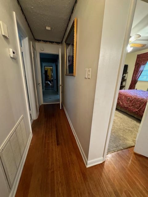 hallway featuring hardwood / wood-style floors and a textured ceiling