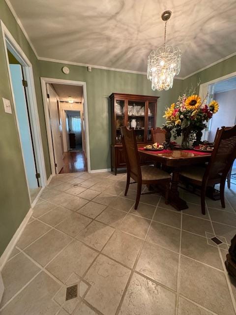 tiled dining space with an inviting chandelier and crown molding