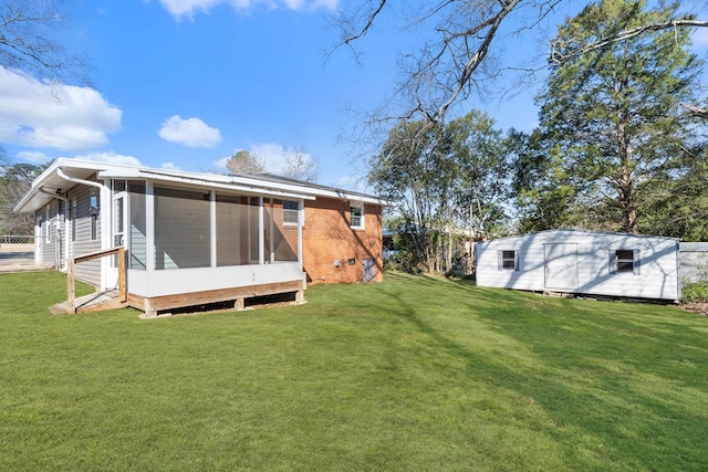 back of house featuring a sunroom, brick siding, and a lawn