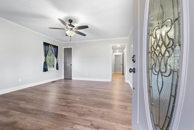 foyer entrance featuring dark wood-style floors, ceiling fan, ornamental molding, and a textured ceiling