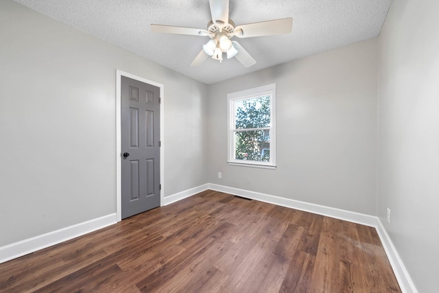 empty room featuring dark wood-style floors, a textured ceiling, baseboards, and a ceiling fan