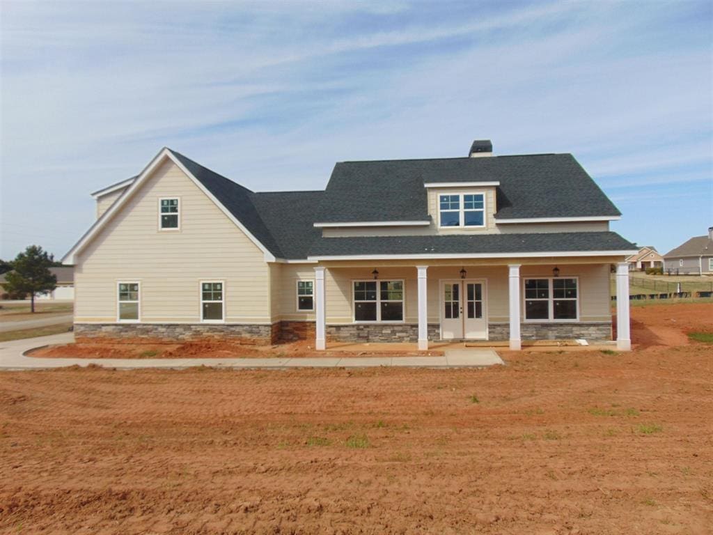 rear view of property with a porch and a yard