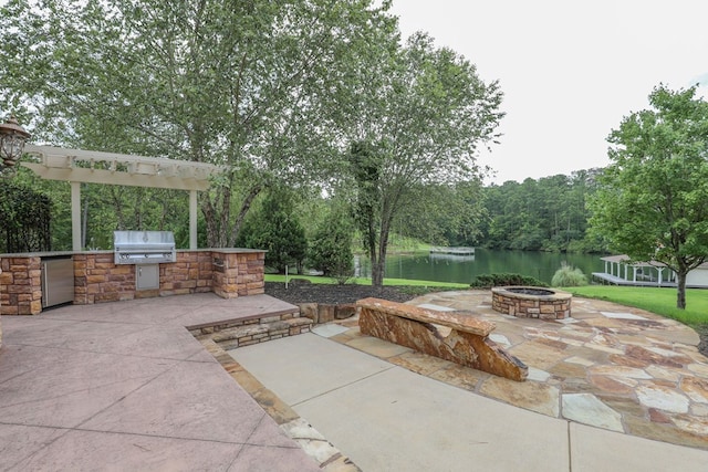 view of patio with area for grilling, a water view, grilling area, and an outdoor fire pit