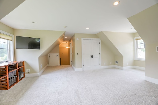 bonus room featuring light colored carpet and lofted ceiling