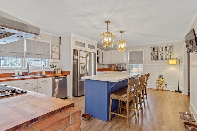 3657 Sussex Dr, Milledgeville, GA 31061 - kitchen featuring appliances with stainless steel finishes, a sink, light countertops, an inviting chandelier, and white cabinetry
