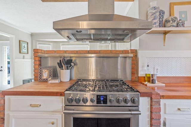 3657 Sussex Dr, Milledgeville, GA 31061 - kitchen with exhaust hood, wooden counters, stainless steel gas range oven, open shelves, and ornamental molding