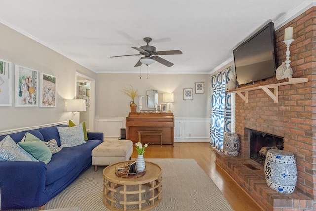 3657 Sussex Dr, Milledgeville, GA 31061 - living room featuring crown molding, wainscoting, wood finished floors, a fireplace, and ceiling fan