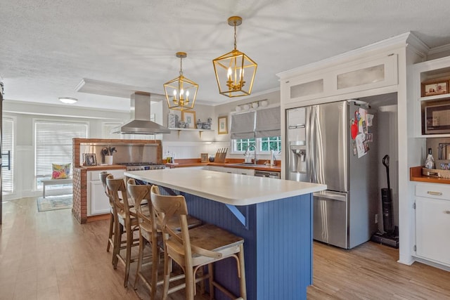 3657 Sussex Dr, Milledgeville, GA 31061 - kitchen featuring ventilation hood, stainless steel appliances, light wood-style flooring, and white cabinets