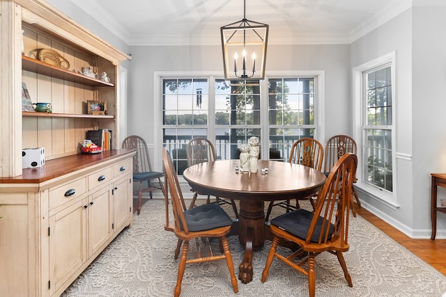 dining area with ornamental molding, a chandelier, and light wood-type flooring