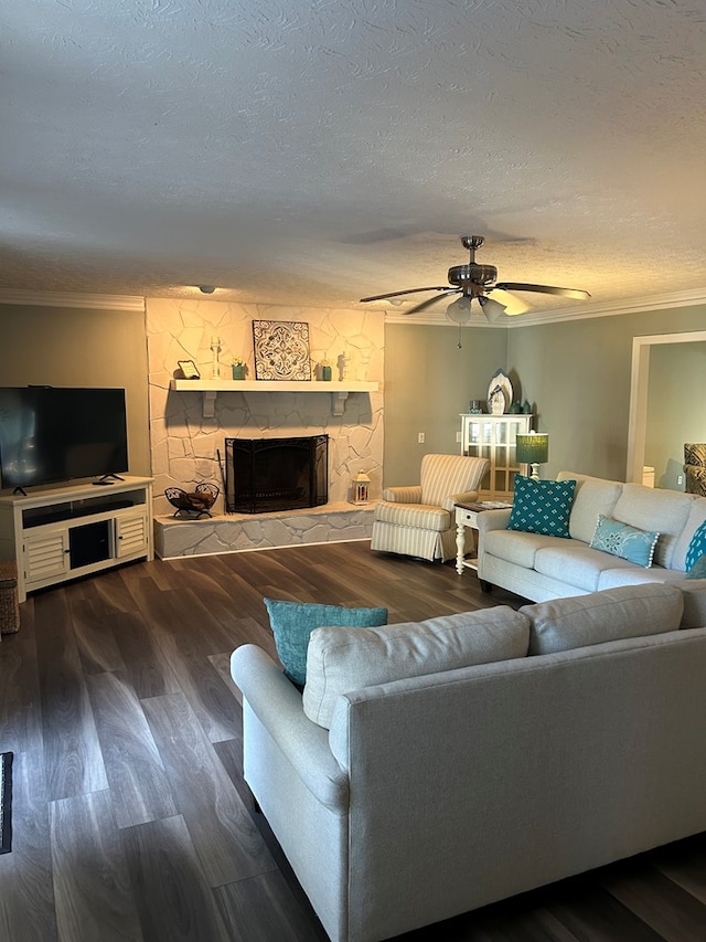 living room featuring a textured ceiling, crown molding, dark hardwood / wood-style flooring, and a fireplace