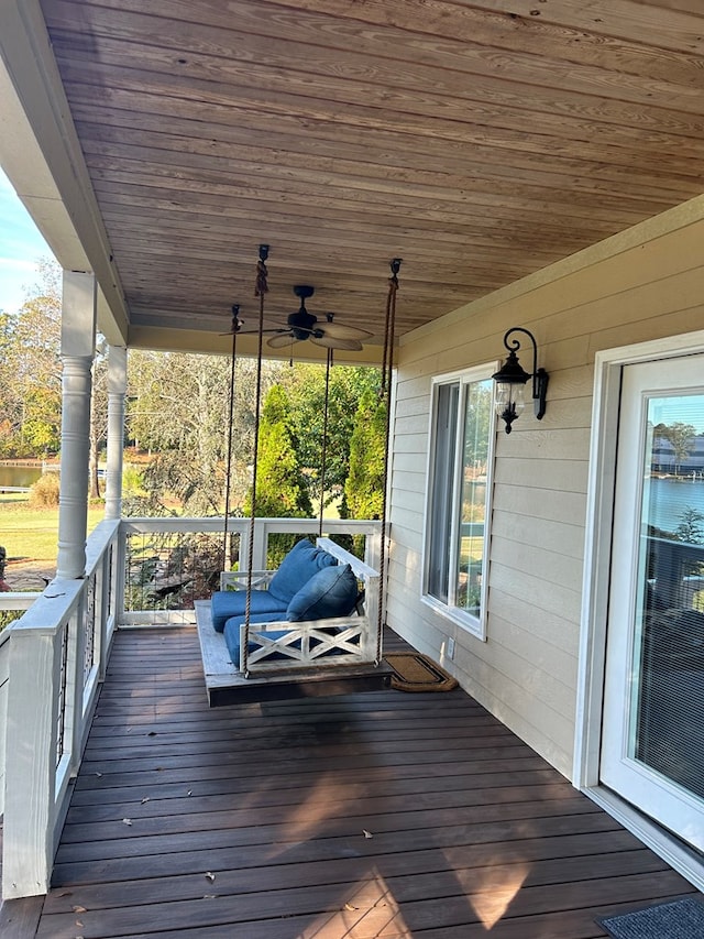 wooden deck featuring ceiling fan, a water view, and covered porch