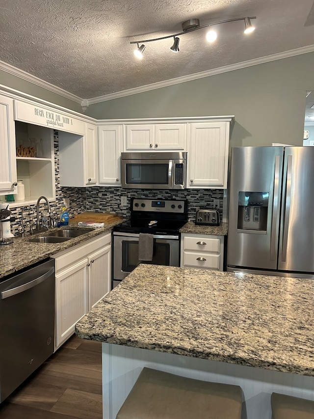 kitchen with white cabinets, stone countertops, appliances with stainless steel finishes, and tasteful backsplash