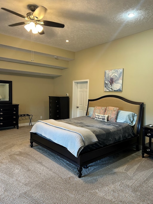 bedroom featuring ceiling fan, carpet floors, and a textured ceiling