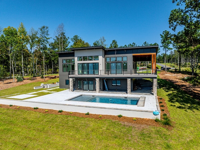 rear view of house featuring a yard, a patio, and a balcony