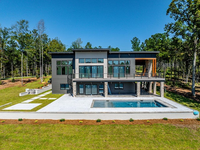 back of property featuring a yard, a balcony, and a patio area