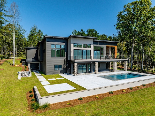 back of house featuring a lawn, a balcony, and a patio