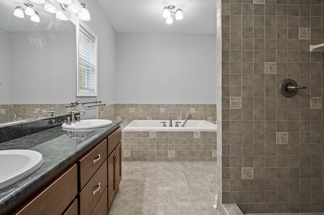 bathroom featuring tiled bath, tile patterned flooring, and vanity