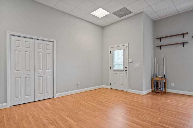 foyer with light wood-type flooring and a paneled ceiling