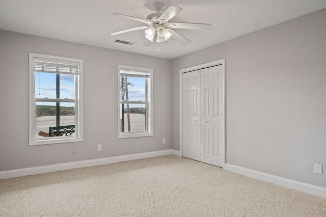 unfurnished bedroom with carpet, ceiling fan, and a closet