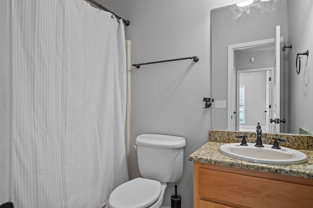 bathroom featuring a shower with shower curtain, vanity, and toilet