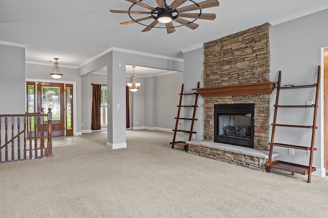 carpeted living room featuring ceiling fan with notable chandelier, crown molding, and a fireplace