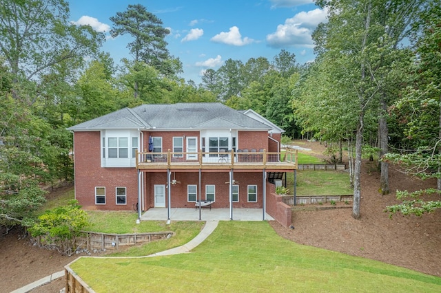 rear view of house featuring a lawn, a deck, and a patio