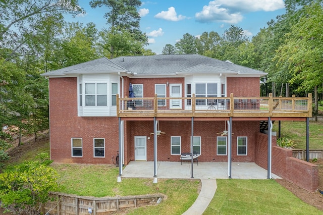 back of house featuring a lawn, a patio area, and a wooden deck