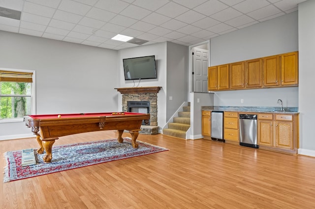 rec room featuring light hardwood / wood-style floors, a stone fireplace, pool table, and sink