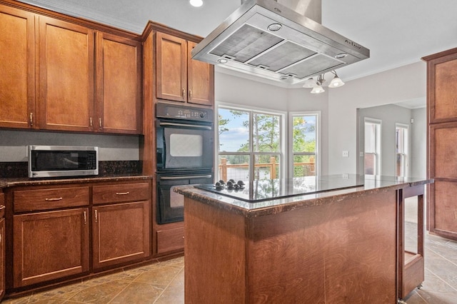 kitchen with a center island, exhaust hood, dark stone counters, light tile patterned floors, and double oven