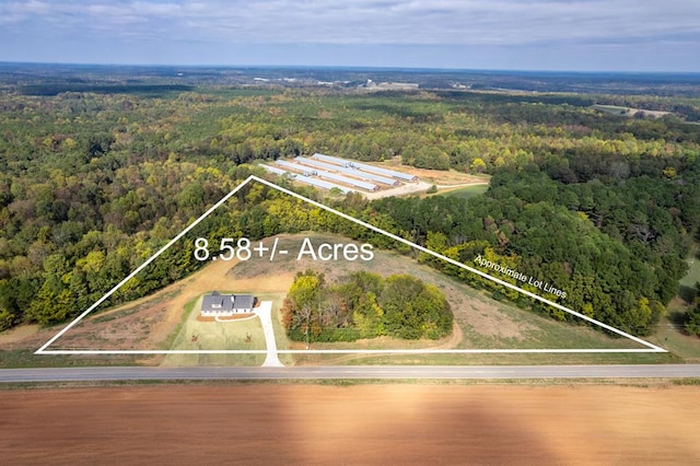 drone / aerial view featuring a water view and a wooded view