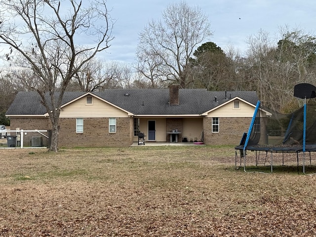 back of property featuring a patio area and a trampoline