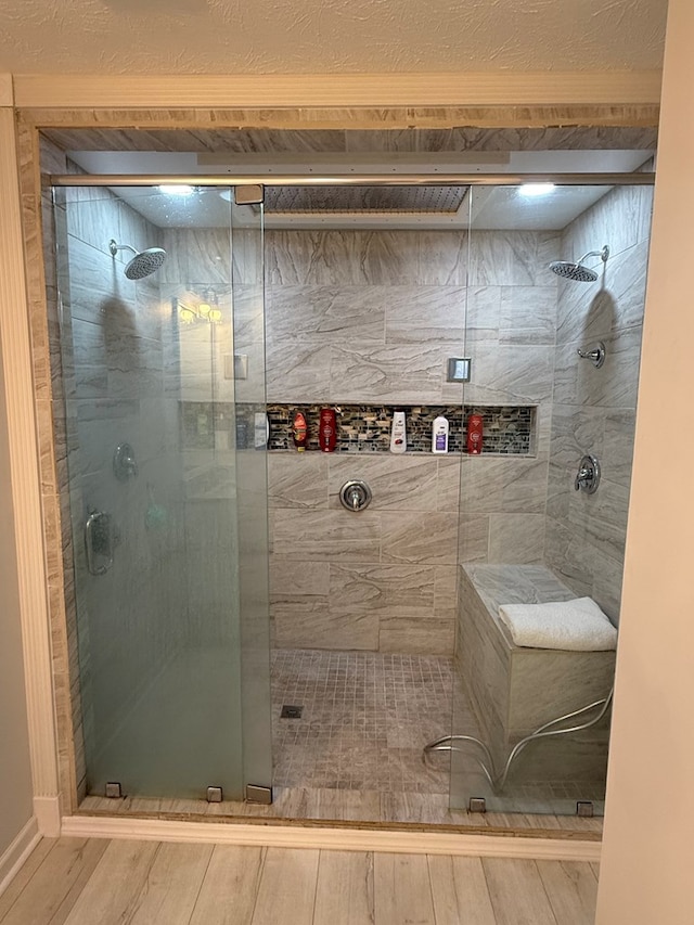 bathroom with a shower with door and wood-type flooring