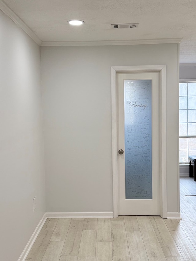 doorway with light hardwood / wood-style flooring and ornamental molding