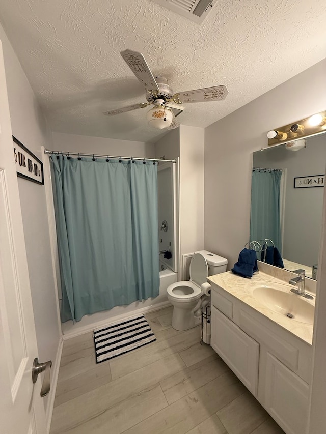 full bathroom with shower / bath combination with curtain, toilet, a textured ceiling, and vanity