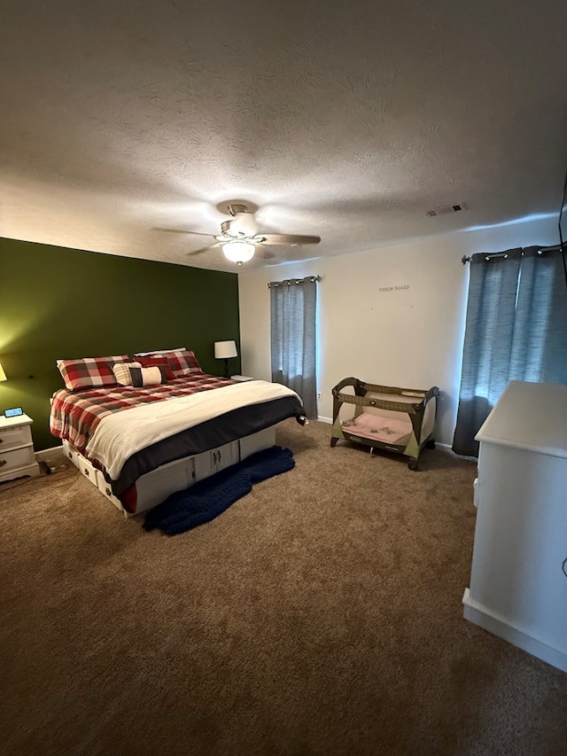 carpeted bedroom with ceiling fan and a textured ceiling