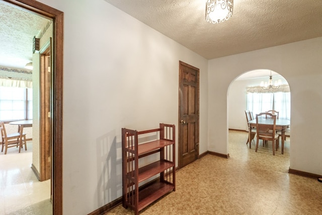 882 Gaissert Church Rd, Sparta, GA 31087 - hallway with a textured ceiling and an inviting chandelier