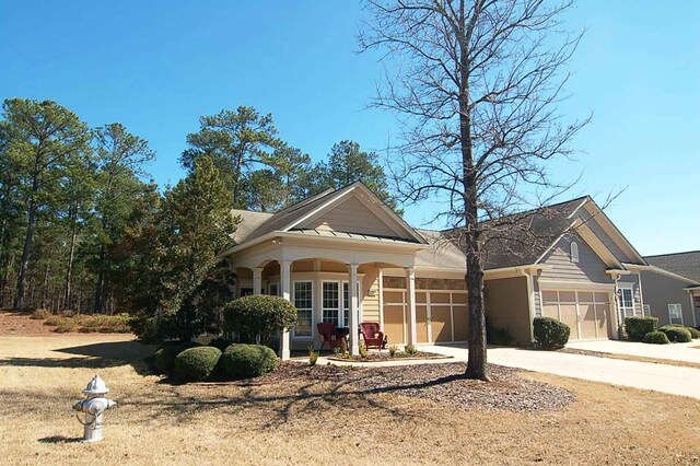 view of front of home with an attached garage, a porch, and driveway