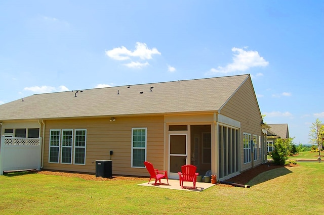 back of property with a lawn, a patio, and a sunroom