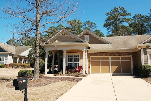 view of front of property with stone siding, driveway, and a garage