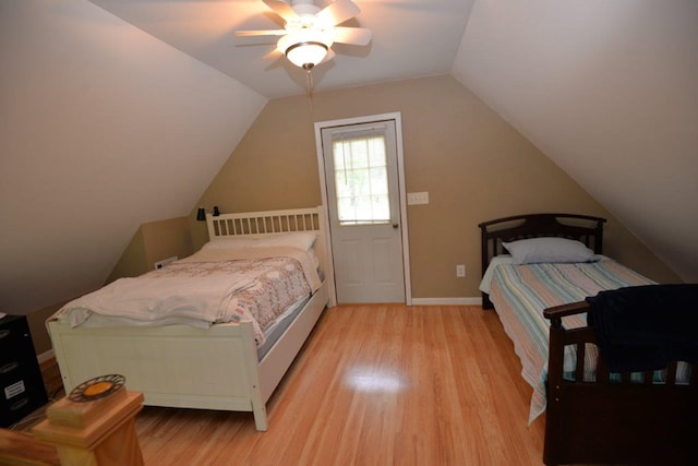 bedroom with light wood-style flooring, baseboards, a ceiling fan, and vaulted ceiling