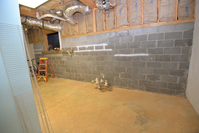 unfinished basement featuring concrete block wall