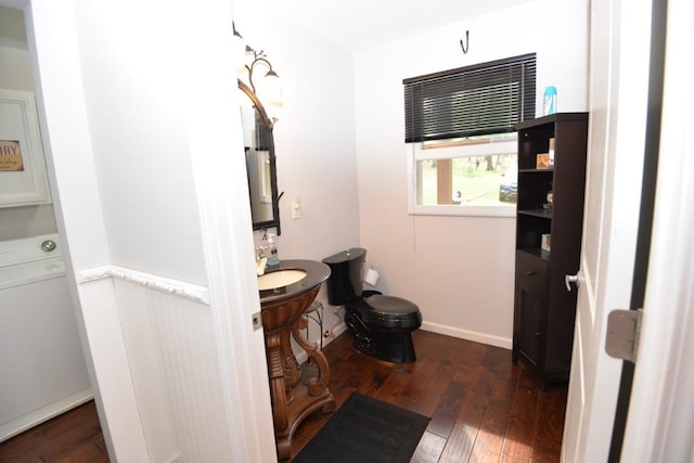bathroom featuring washer / dryer, hardwood / wood-style floors, and toilet