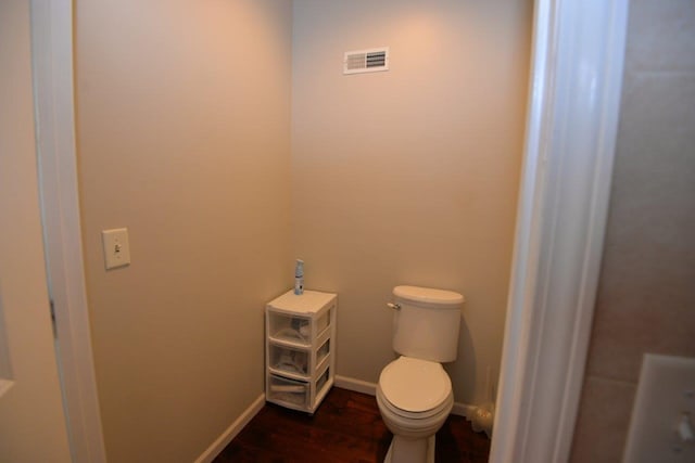 bathroom with visible vents, toilet, wood finished floors, and baseboards