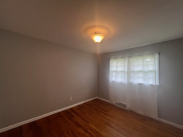 empty room with dark wood-type flooring