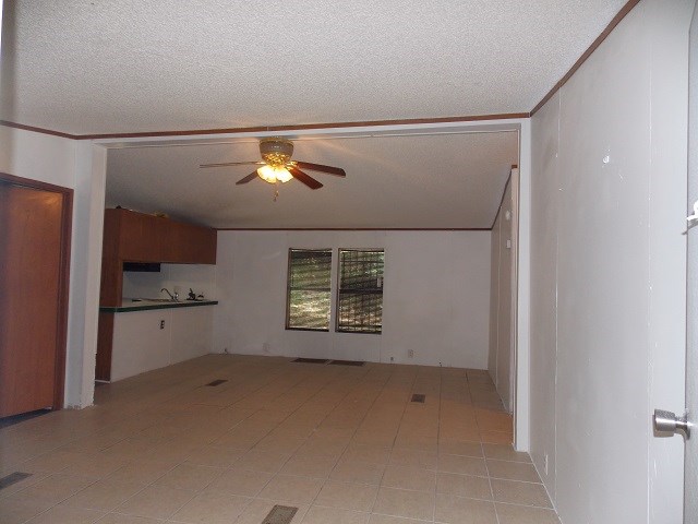 unfurnished room with a textured ceiling and ceiling fan