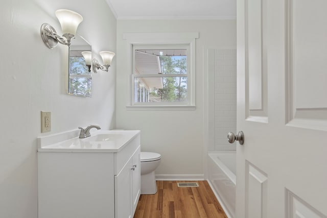 full bathroom with hardwood / wood-style floors, shower / bathing tub combination, vanity, toilet, and ornamental molding