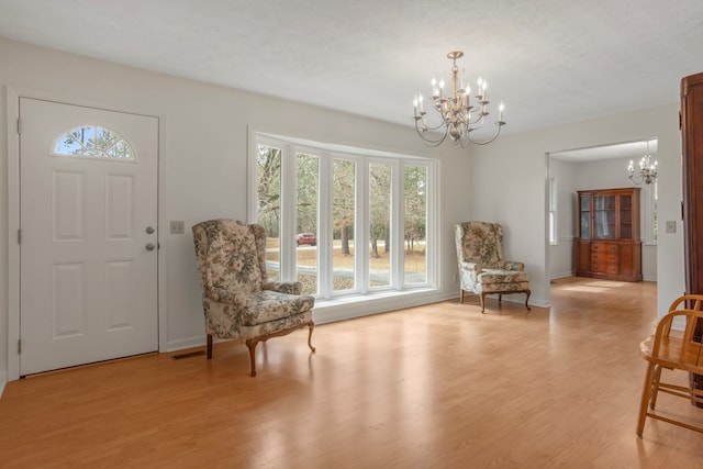 unfurnished room with light hardwood / wood-style flooring, a textured ceiling, and a notable chandelier